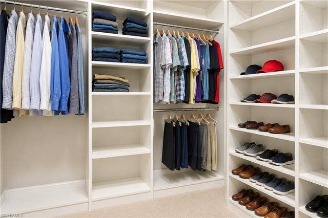 28410 Capraia Dr, Bonita Springs, FL 34135 Custom closet system featuring multiple hanging rods, integrated shelving, and dedicated shoe storage