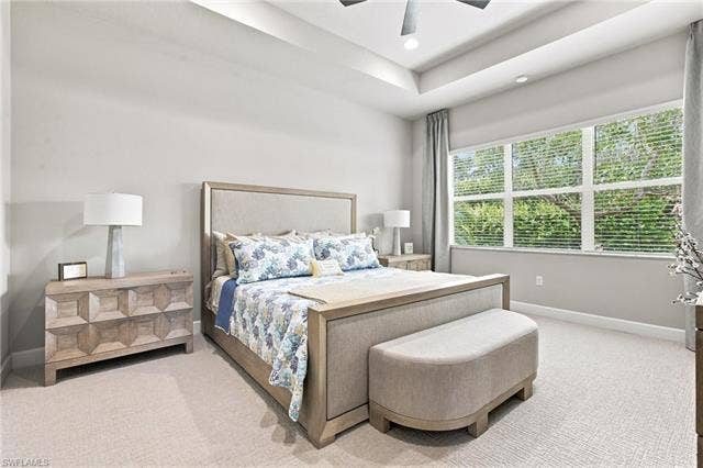 28410 Capraia Dr, Bonita Springs, FL 34135 Recessed lighting, tray ceiling, carpet flooring, multiple large windows, and a ceiling fan