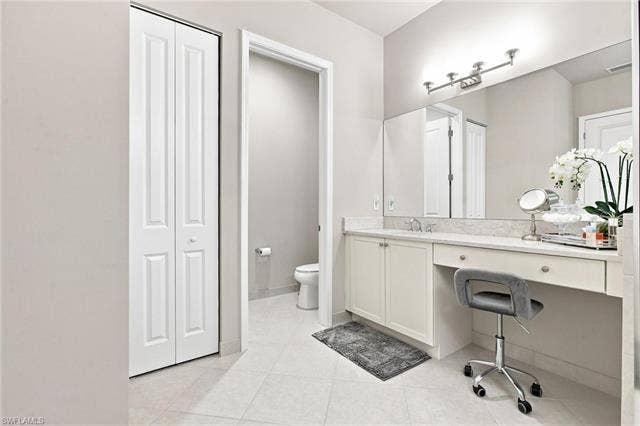 28410 Capraia Dr, Bonita Springs, FL 34135 Recessed vanity with stone countertop, integrated sink, and undermount cabinetry