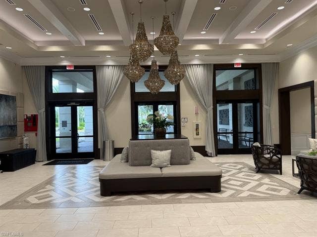 28410 Capraia Dr, Bonita Springs, FL 34135 Recessed lighting, layered tray ceiling, light-colored tile flooring, multiple chandeliers, and full-height windows