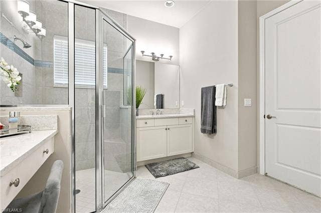 28410 Capraia Dr, Bonita Springs, FL 34135 Glass-enclosed shower with tile surround and integrated bench