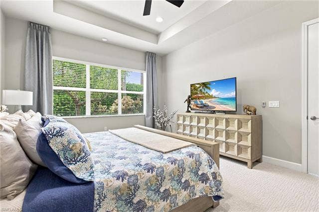 28410 Capraia Dr, Bonita Springs, FL 34135 Tray ceiling with recessed lighting, ceiling fan, large window with blinds, and light-colored carpet