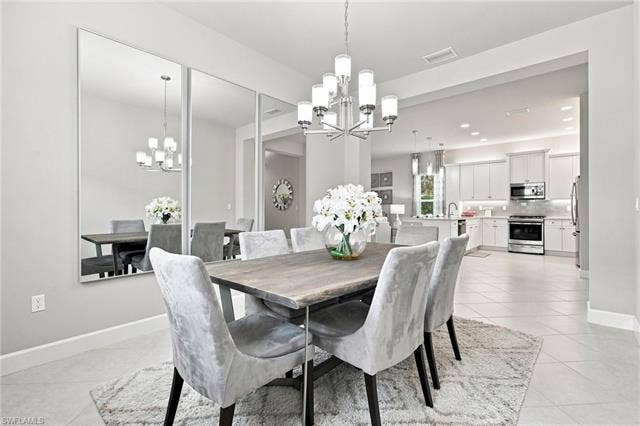 28410 Capraia Dr, Bonita Springs, FL 34135 Open concept dining area with tile flooring, featuring a chandelier and recessed lighting