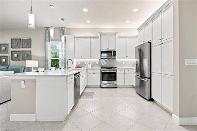 28410 Capraia Dr, Bonita Springs, FL 34135 Kitchen with white cabinetry, stainless steel appliances, a center island with sink, tile flooring, and recessed lighting