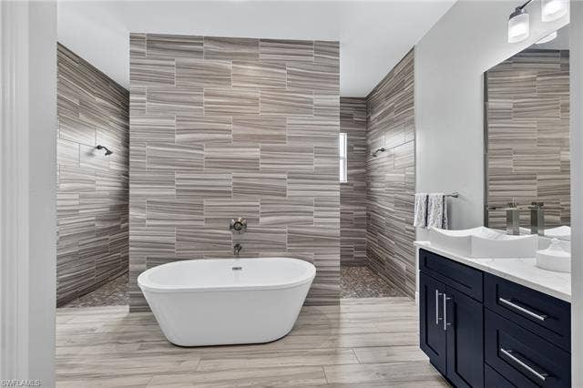 27150 Rue De Paix, Bonita Springs, FL 34135 Freestanding soaking tub with a wall-mounted faucet, 12ft walk-in shower, dual vanities with rectangular vessel sinks and white quartz countertops