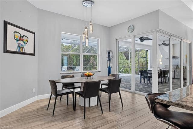 27150 Rue De Paix, Bonita Springs, FL 34135 Wood-finish flooring throughout, modern pendant lighting, large windows, and multi-panel sliding glass doors