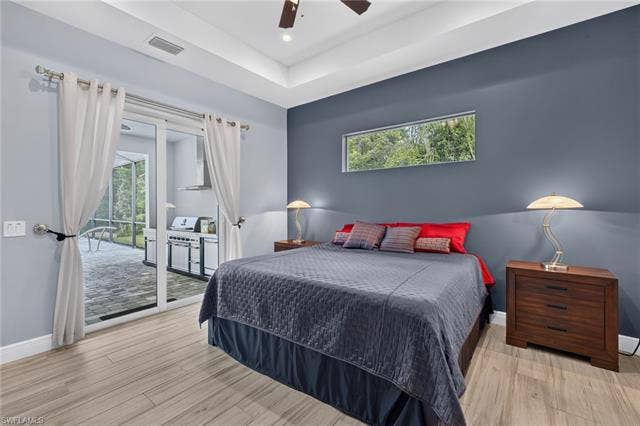 27150 Rue De Paix, Bonita Springs, FL 34135 Plank tile flooring, sliding glass door, modern linear window, tray ceiling, and ceiling fan