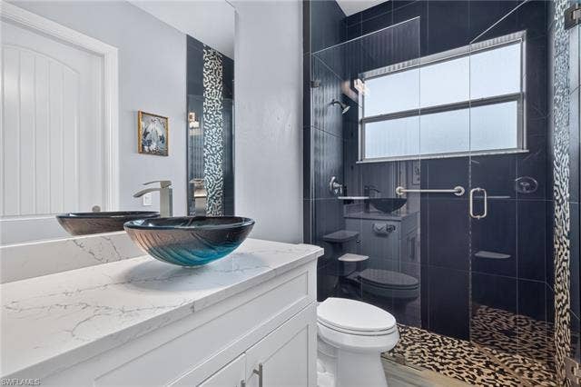 27150 Rue De Paix, Bonita Springs, FL 34135 White vanity with a vessel sink, single-handle faucet, quartz countertop and designer shower with frameless glass shower door
