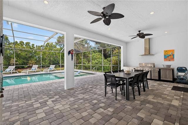 27150 Rue De Paix, Bonita Springs, FL 34135 Covered outdoor living space with tropical ceiling fans, recessed lighting, paver patio and lanai and fully equipped outdoor kitchen