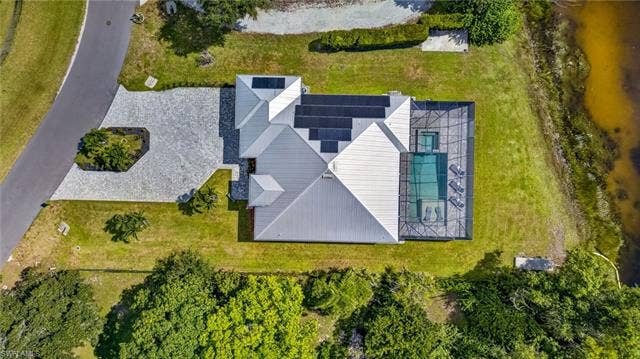 27150 Rue De Paix, Bonita Springs, FL 34135 Spacious property with a large paver driveway, integrated solar panels, screened pool enclosure