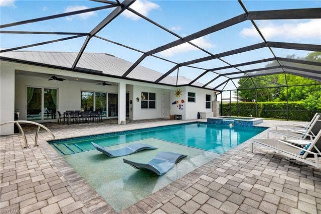 27150 Rue De Paix, Bonita Springs, FL 34135 Custom pool with sun shelf, pool loungers, integrated spa, large screened enclosure and door into 3rd full bathroom