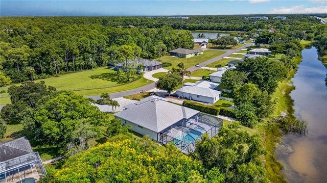 27150 Rue De Paix, Bonita Springs, FL 34135 Screened-in pool, waterside property, lush surrounding foliage, mature trees, custom built home in the Lakes of Sans Souci neighborhood, LOW HOA