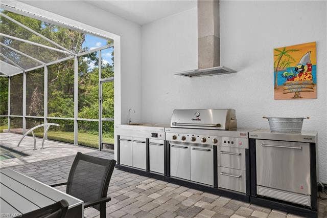 27150 Rue De Paix, Bonita Springs, FL 34135 Outdoor kitchen featuring stainless steel appliances, a built-in grill, and a range hood