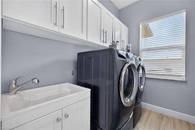 27150 Rue De Paix, Bonita Springs, FL 34135 White shaker-style upper cabinetry, deep utility sink with chrome faucet, and Electrolux washer and dryer
