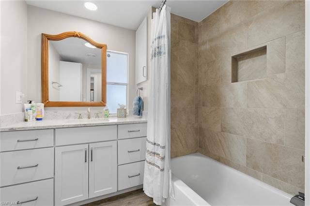 60 Palos Dr, Naples, FL 34104 Updated guest bathroom with a tiled tub and shower surround.