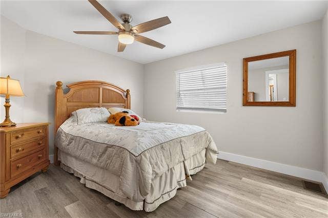 60 Palos Dr, Naples, FL 34104 Comfortable guest bedroom with wide-plank flooring and neutral finishes.