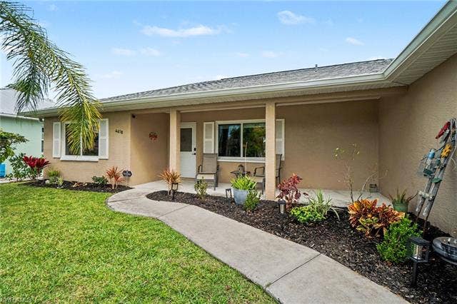4618 Sierra Ln, Bonita Springs, FL 34134 Front elevation with light tan stucco finish and a covered entry