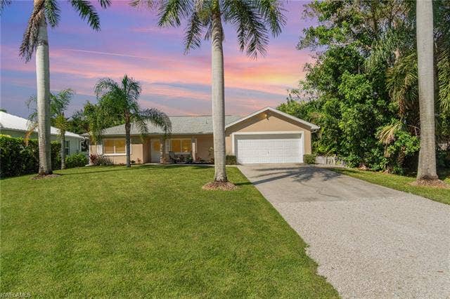 4618 Sierra Ln, Bonita Springs, FL 34134 Single-story residence featuring a two-car garage, concrete driveway, and stucco exterior