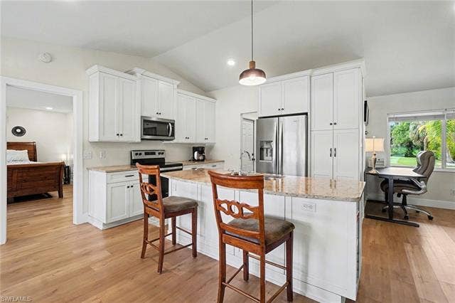 4618 Sierra Ln, Bonita Springs, FL 34134 Kitchen featuring white cabinetry, stainless steel appliances, granite countertops, and wood-finish flooring