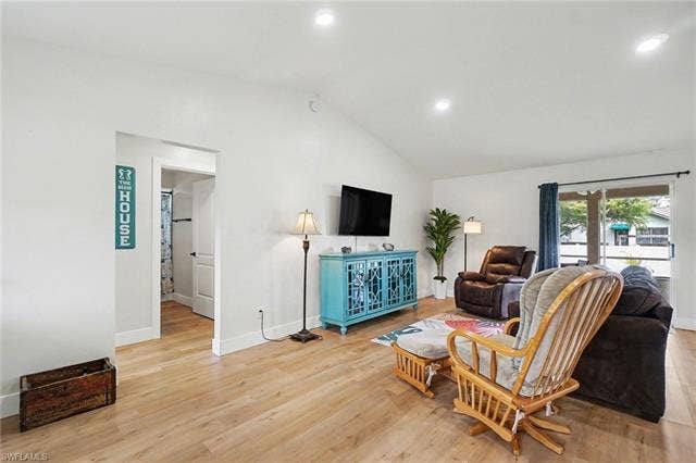 4618 Sierra Ln, Bonita Springs, FL 34134 Vaulted ceiling living area featuring wood-finish flooring, recessed lighting, and a sliding glass door