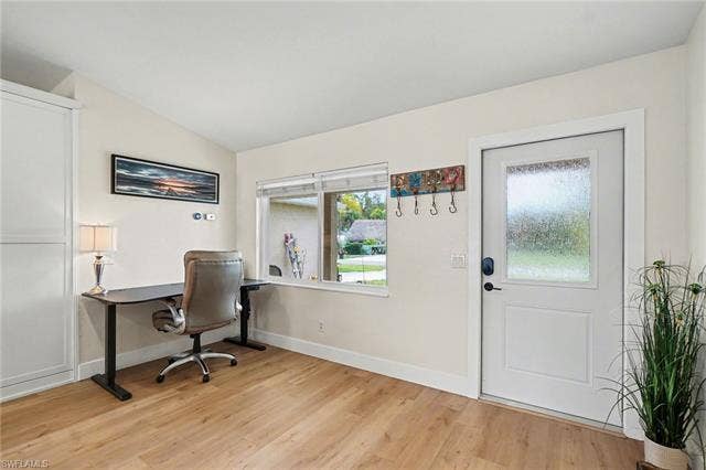 4618 Sierra Ln, Bonita Springs, FL 34134 Wood-finish flooring throughout, white trim, and a white paneled door with a frosted glass insert