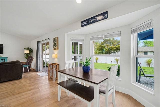 4618 Sierra Ln, Bonita Springs, FL 34134 Bay windows, wood-finish flooring, white walls, and a sliding glass door to the exterior