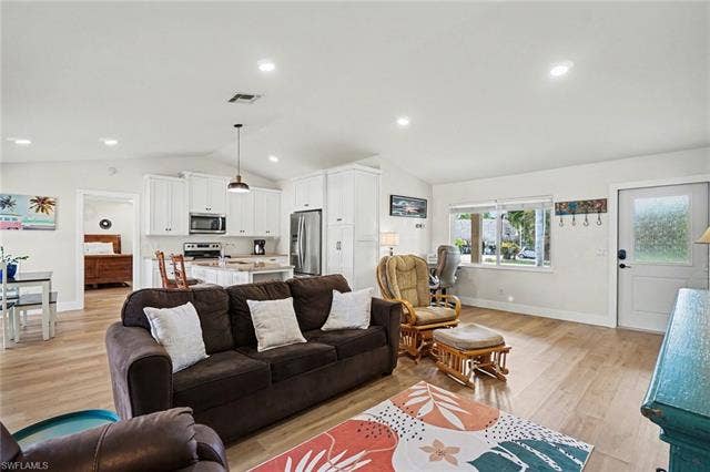 4618 Sierra Ln, Bonita Springs, FL 34134 Vaulted ceilings, wood-finish flooring, recessed lighting, white cabinetry, and stainless steel appliances