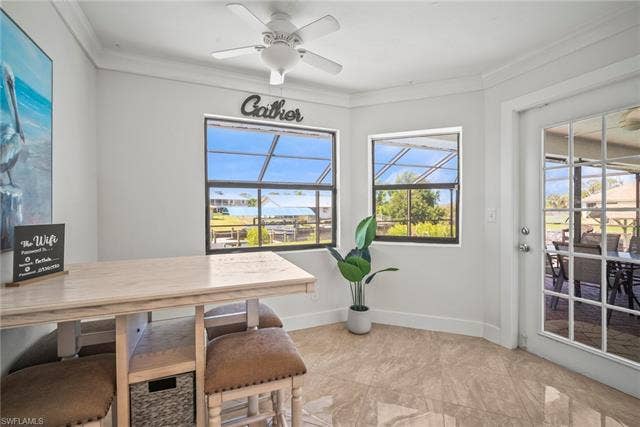 20640 Porthole Ct, Estero, FL 33928 Dining room featuring a ceiling fan, baseboards, and ornamental molding