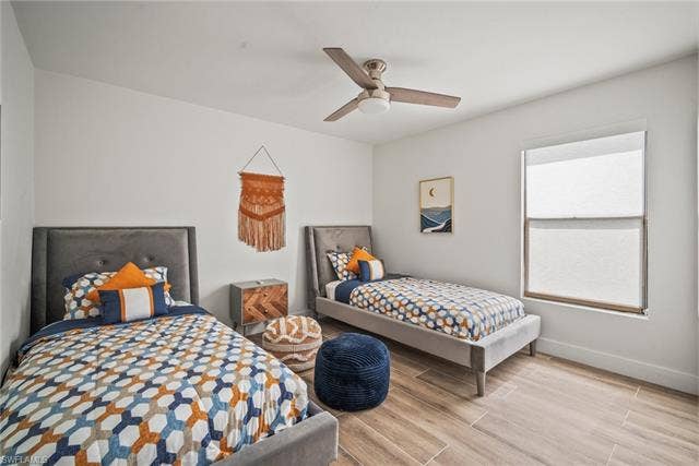 20640 Porthole Ct, Estero, FL 33928 Bedroom featuring ceiling fan, baseboards, and wood finished floors