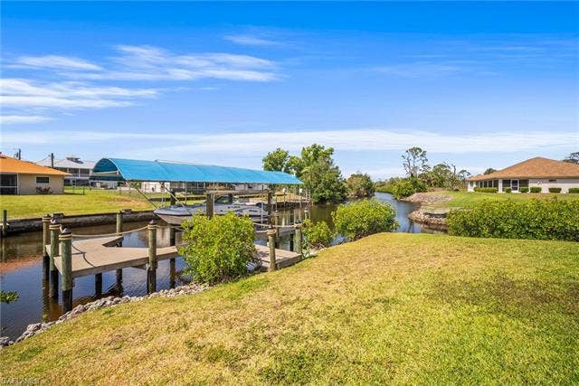20640 Porthole Ct, Estero, FL 33928 View of dock with a lawn, boat lift, and a water view