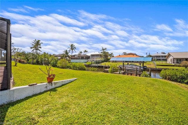 20640 Porthole Ct, Estero, FL 33928 View of yard with a water view, boat lift, a residential view, and a dock