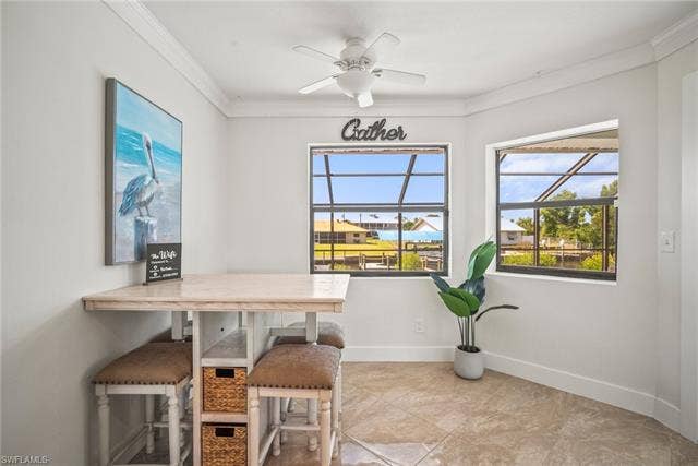 20640 Porthole Ct, Estero, FL 33928 Dining area with ceiling fan, baseboards, and ornamental molding