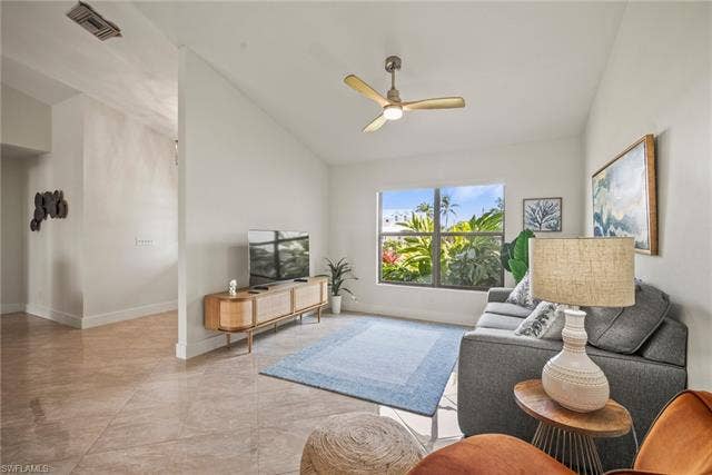 20640 Porthole Ct, Estero, FL 33928 Living room with lofted ceiling, visible vents, baseboards, and ceiling fan