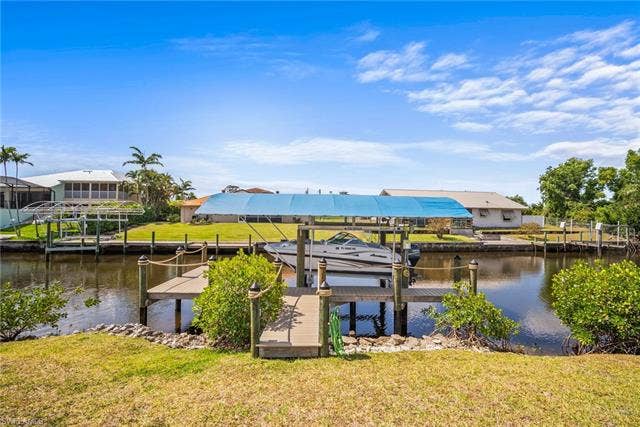 20640 Porthole Ct, Estero, FL 33928 Dock area featuring a yard, boat lift, and a water view