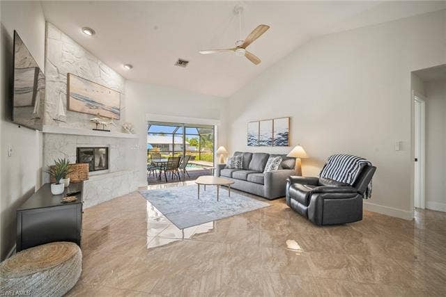 20640 Porthole Ct, Estero, FL 33928 Living area featuring baseboards, visible vents, ceiling fan, high vaulted ceiling, and a high end fireplace