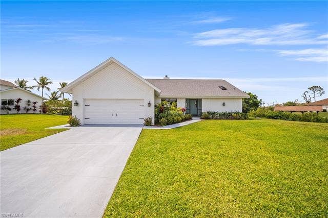 20640 Porthole Ct, Estero, FL 33928 Ranch-style home with an attached garage, driveway, and a front lawn