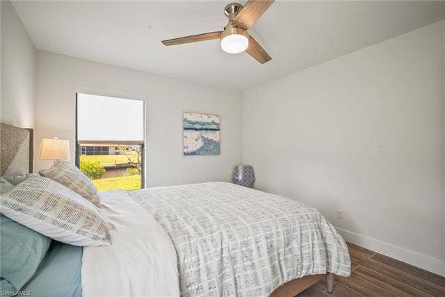 20640 Porthole Ct, Estero, FL 33928 Bedroom with baseboards, a ceiling fan, and wood finished floors