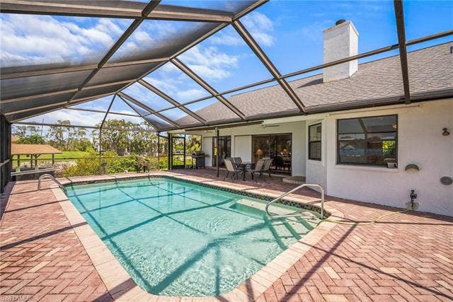 20640 Porthole Ct, Estero, FL 33928 Outdoor pool featuring a lanai, a patio, ceiling fan, outdoor dining space, and area for grilling