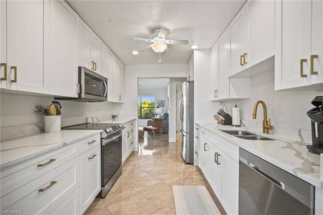 20640 Porthole Ct, Estero, FL 33928 Kitchen with a ceiling fan, a sink, white cabinetry, and appliances with stainless steel finishes