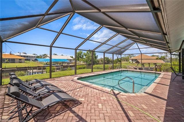 20640 Porthole Ct, Estero, FL 33928 Pool featuring glass enclosure and a patio