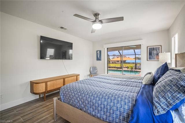 20640 Porthole Ct, Estero, FL 33928 Bedroom featuring multiple windows, baseboards, access to outside, and wood finished floors