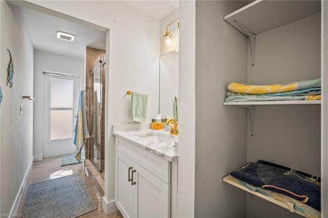 20640 Porthole Ct, Estero, FL 33928 Bathroom with a shower stall, baseboards, vanity, and visible vents