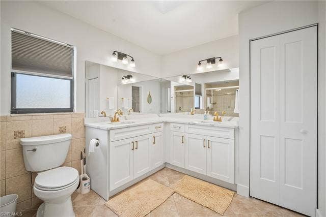 20640 Porthole Ct, Estero, FL 33928 Bathroom featuring a sink, tile patterned floors, a closet, a stall shower, and double vanity