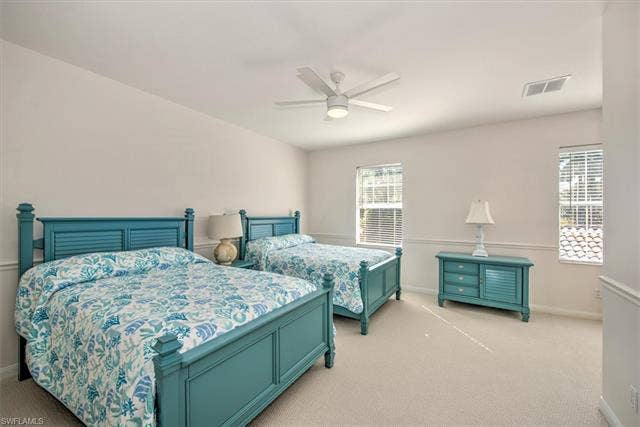 15059 Blue Marlin Ter, Bonita Springs, FL 34135 Neutral wall paint, ceiling fan with integrated lighting, two windows with blinds, and light-colored carpeting