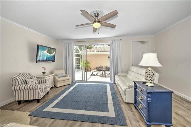 15059 Blue Marlin Ter, Bonita Springs, FL 34135 Waterproof vinyl Wood-color finish flooring, first floor crown molding, and a ceiling fan with integrated lighting