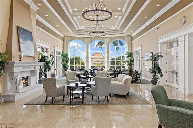 15059 Blue Marlin Ter, Bonita Springs, FL 34135 Grand hall featuring arched windows, coffered ceilings, polished tile flooring, stone fireplace, and built-in lighting