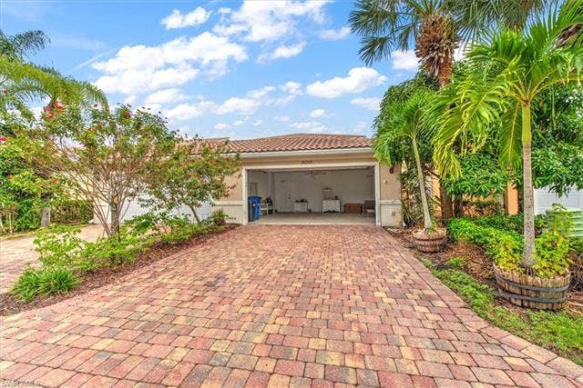 15059 Blue Marlin Ter, Bonita Springs, FL 34135 Paver driveway leading to an attached garage with a tile roof
