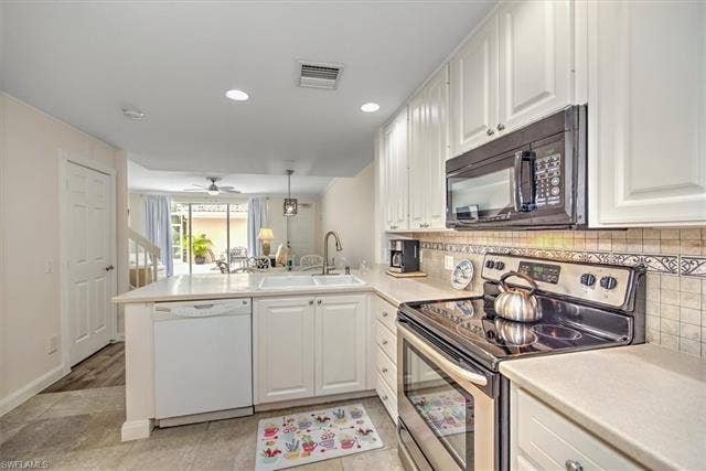 15059 Blue Marlin Ter, Bonita Springs, FL 34135 White cabinetry with an integrated microwave and stainless steel range oven, dishwasher , fridge, freezer, new disposal 10.6.2026/instaledc