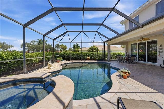 19600 Maddelena Cir, Estero, FL 33967 Screened enclosure featuring a freeform pool, integrated spa, and expansive paver patio