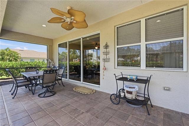 19600 Maddelena Cir, Estero, FL 33967 Screened lanai featuring tile flooring, ceiling fan, and sliding glass doors